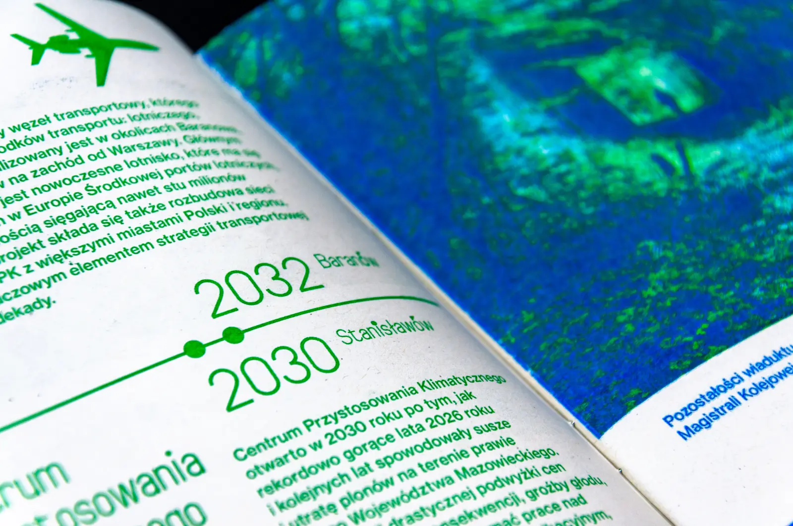 Zbliżenie na publikację, widoczny tekst i fragment zielono-niebieskiej fotografii.