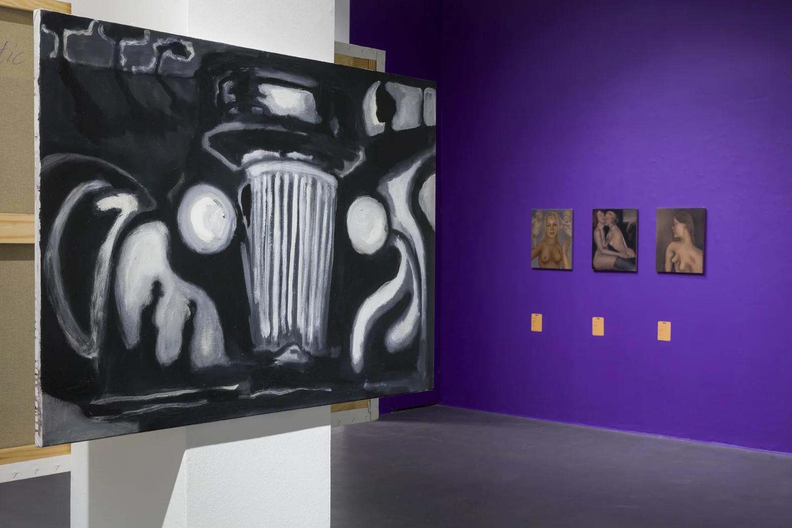 Ekspresjonistyczny, czarno-biały obraz przedstawiający przód samochodu na pierwszym planie, w tle małe portrety na fioletowej ścianie.