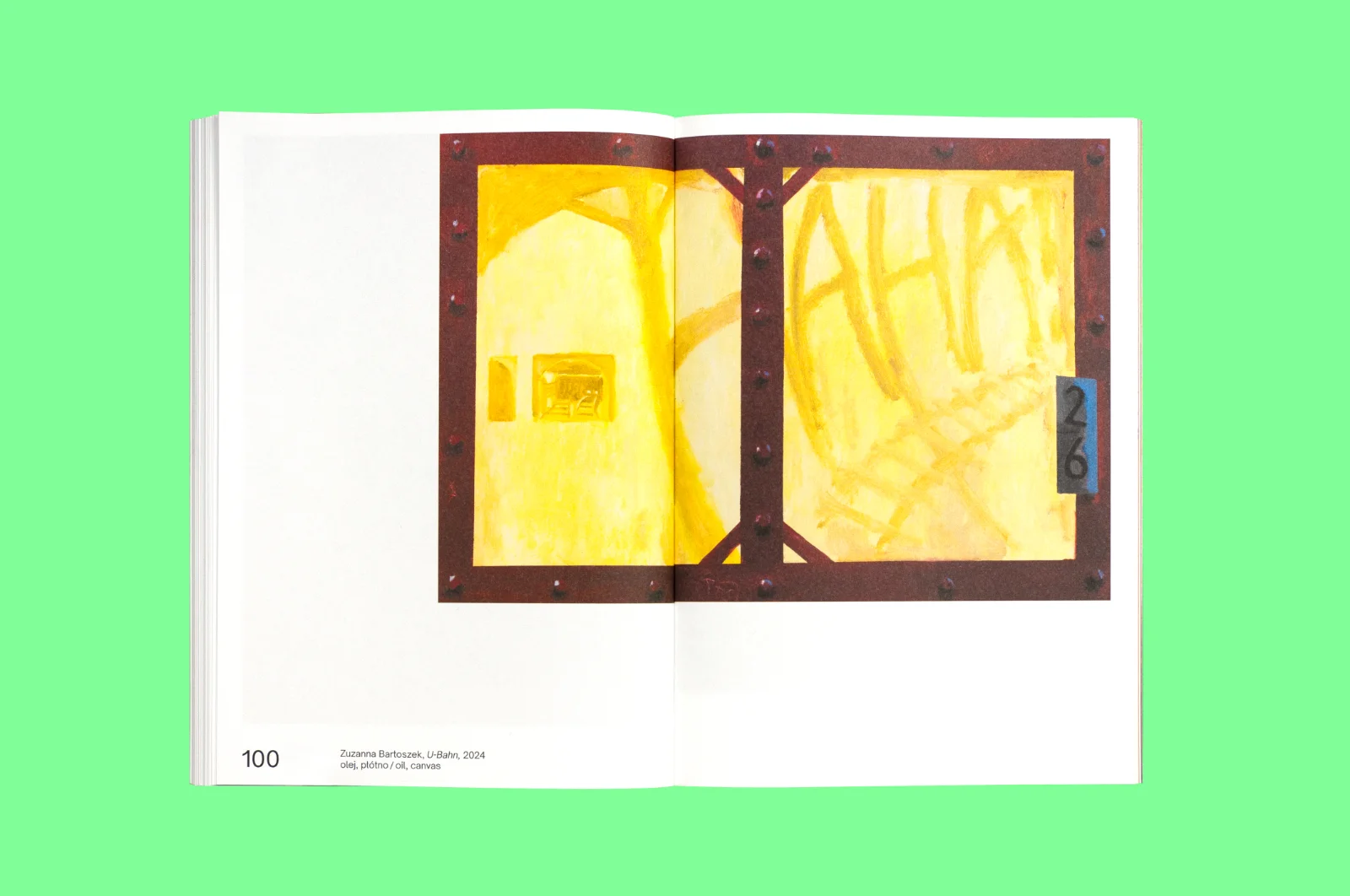 Rozkładówka książki z obrazem Zuzanny Bartoszek „U-Bahn”, przedstawiającym żółte, industrialne wnętrze z namalowanym napisem „AHA”.