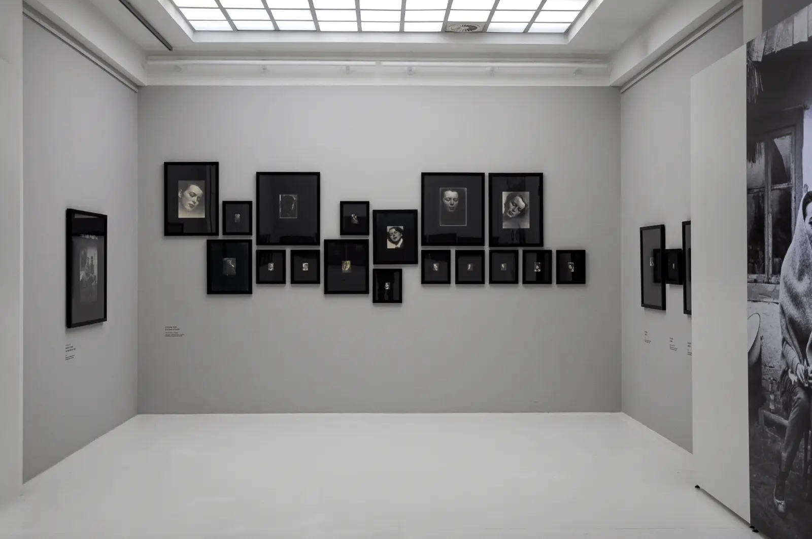 Widok wystawy „Fenomenalny. Zdzisław Beksiński”. Jasnoszara sala z czarno-białym portretami żony Beksińskiego.