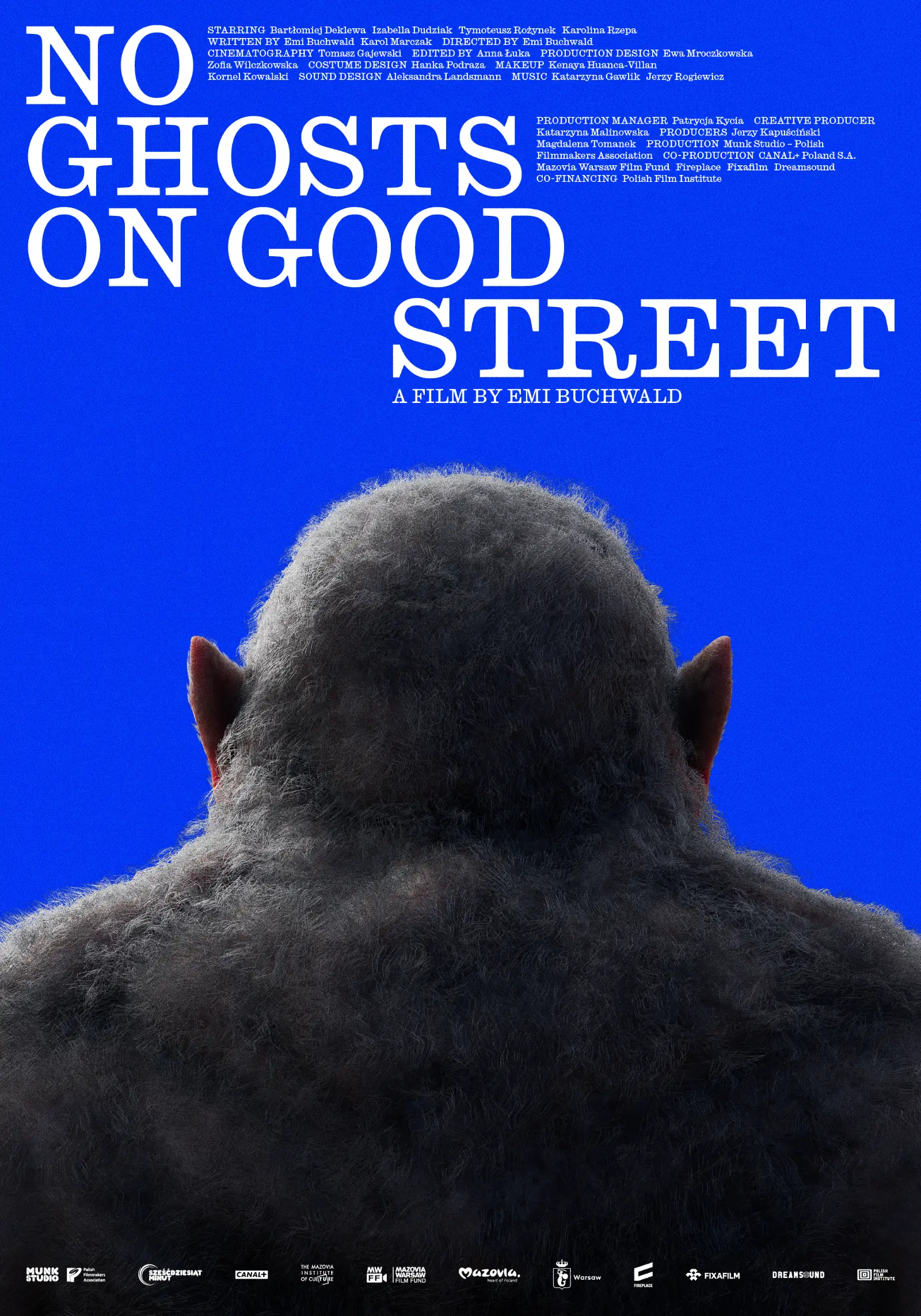 Wersja angielska plakatu do filmu Emi Buchwald „No Ghost on Good Street”. Na niebieskim tle widać od tyłu szarawą, włochatą sylwetkę. W kadrze znajdują się plecy i głowa stwora. Powyżej białe litery z informacjami o filmie: tytuł, autorzy.