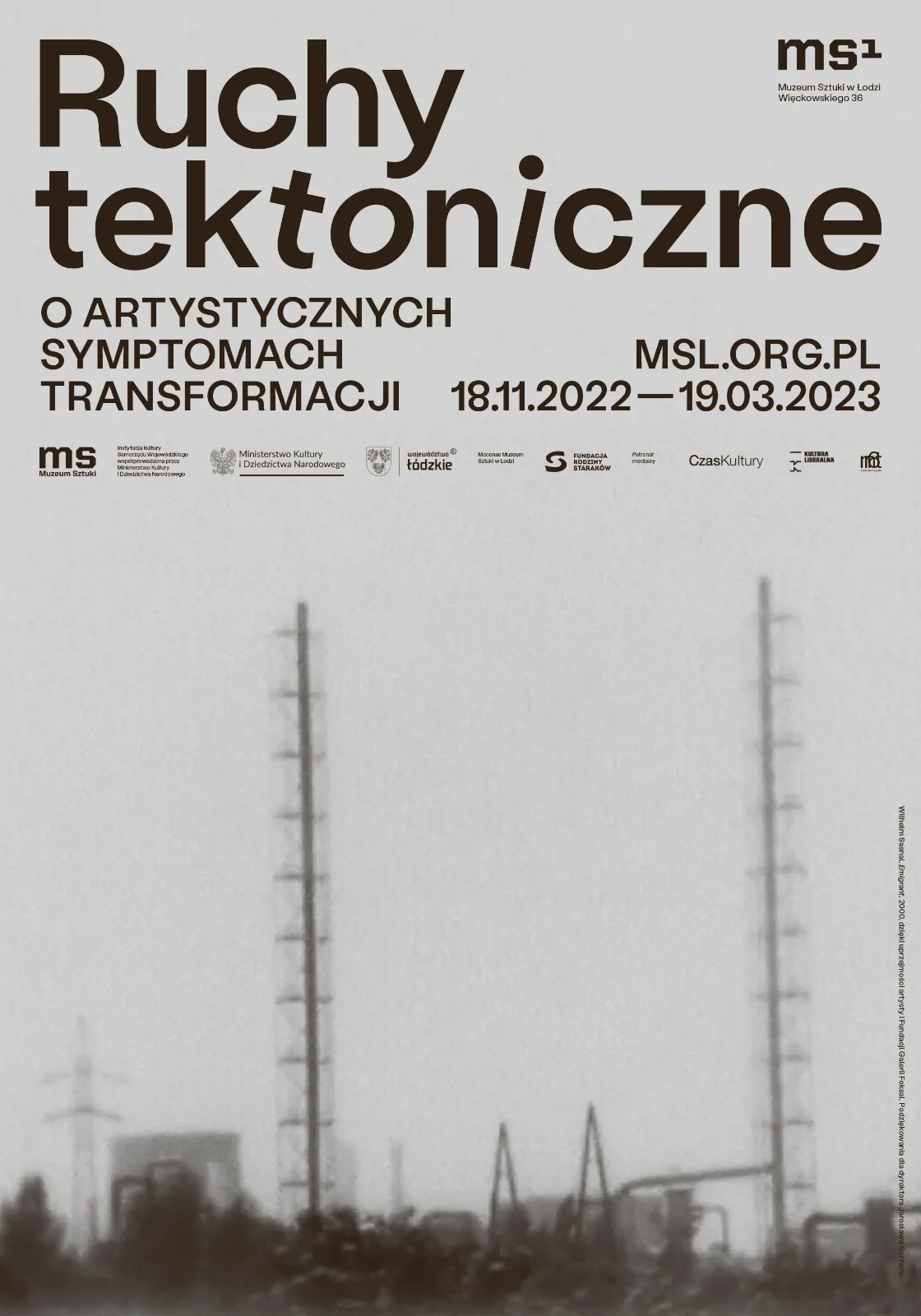 Plakat wystawy z rozmytym, szarym zdjęciem krajobrazu przemysłowego. Na pierwszym planie dwie wysokie, ażurowe wieże transmisyjne. Napisy w kolorze ciemnobrązowym.