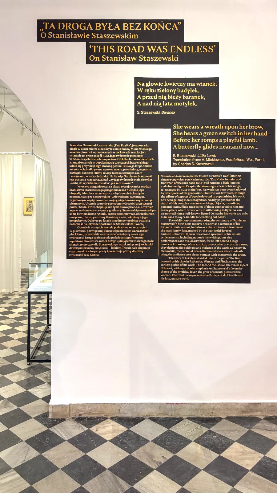Ściana ekspozycyjna z tekstem kuratorskim i wierszem „Baranek”.