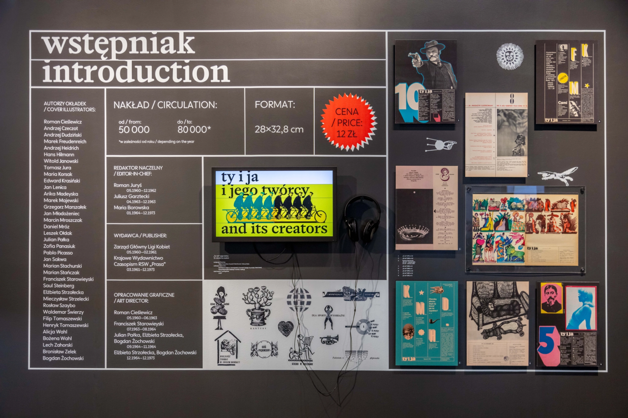 Ściana wystawy z tytułem „wstępniak / introduction” i białą siatką typograficzną namalowaną na czarnym tle: lista autorów okładek i redaktorów, nakład, format, czerwona gwiazdka z ceną, ekran ze słuchawkami i oryginalne strony magazynu.