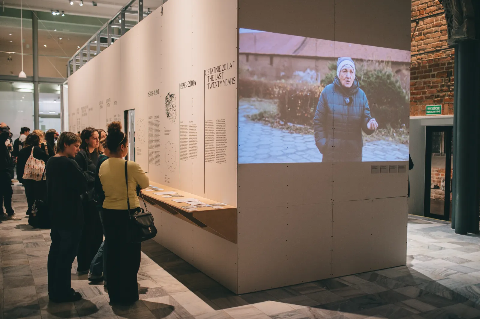 Widok wystawy ze zwiedzającymi.