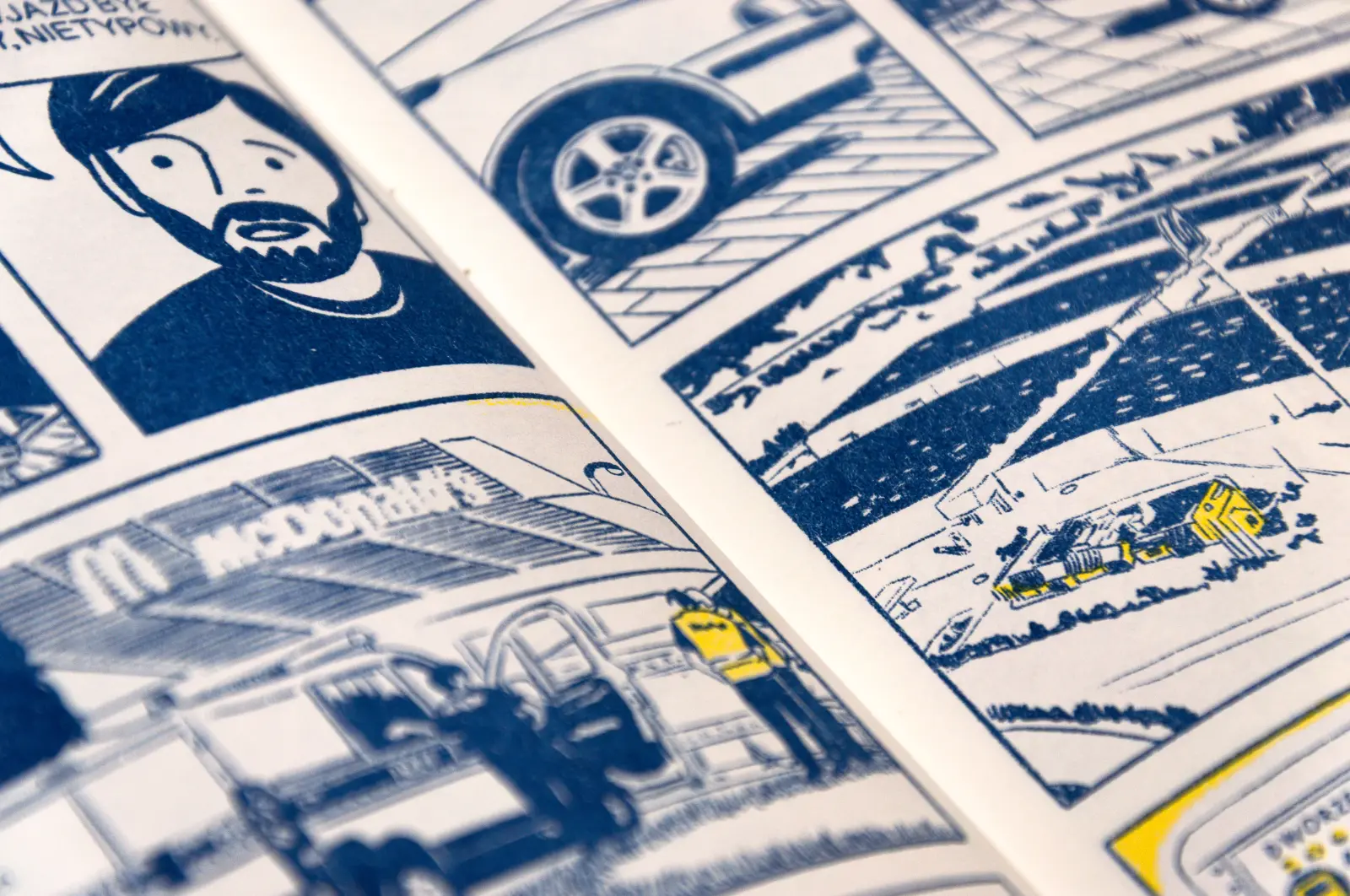 Granatowo-żółty rysunek komiksowy. Twarz głównego bohatera, mężczyny w średnim wieku z brodą. Policyjna furgonetka przed McDonald’sem.