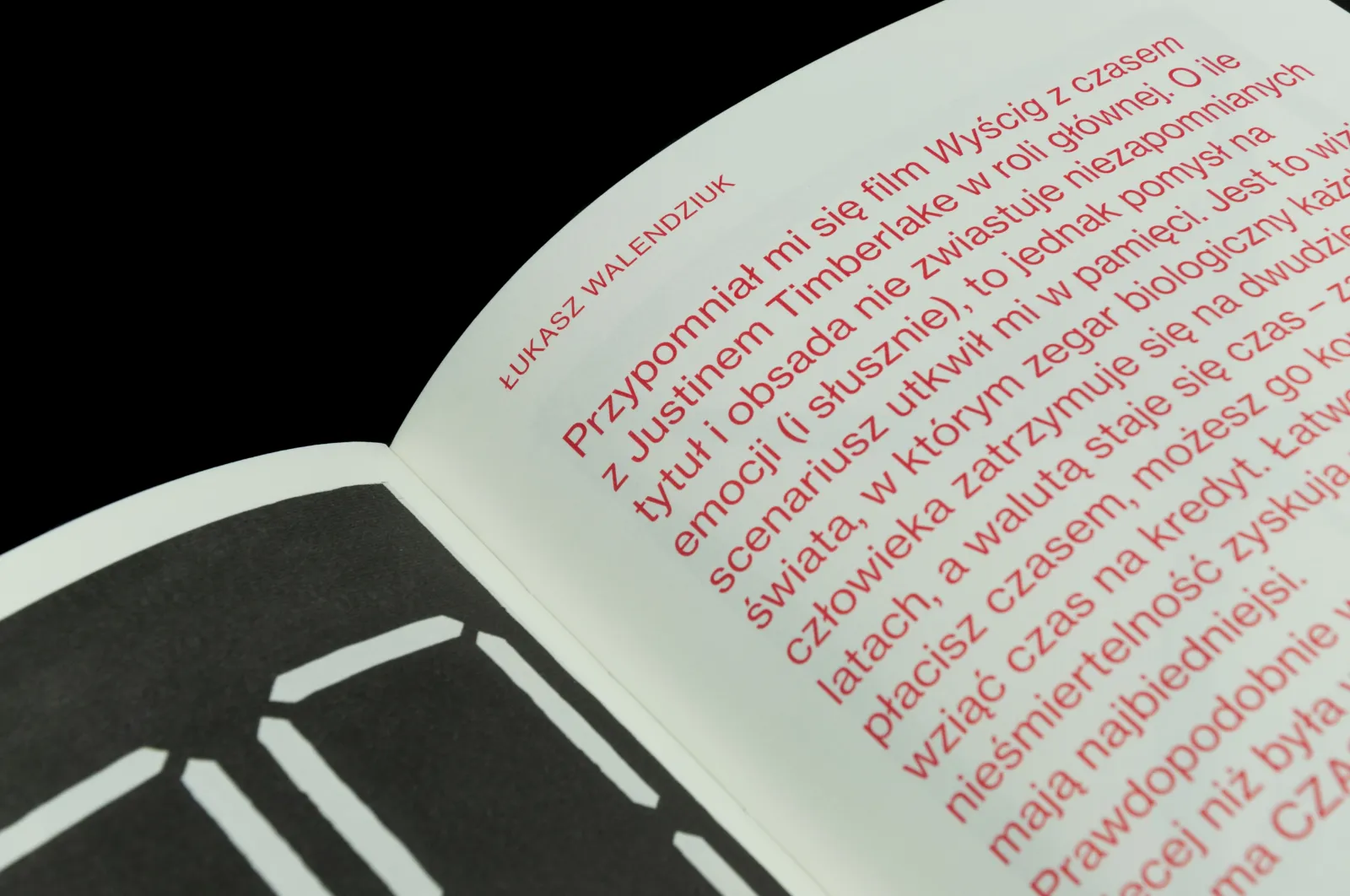 Zbliżenie na fragment książki z czerwoną typografią