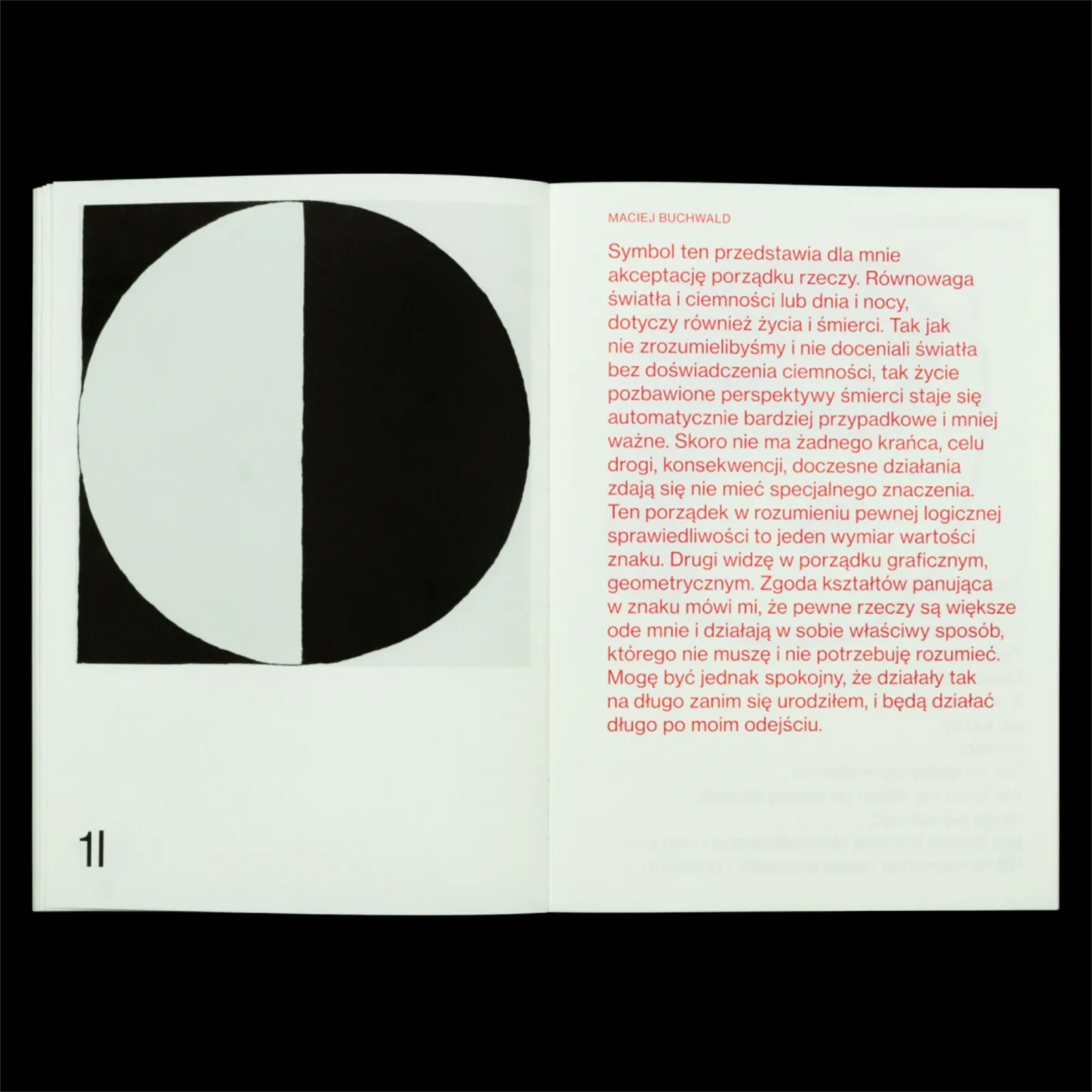 Rozkładówka z w połowie białym, w połowie czarnym kołem na lewej stronie i czerwonym tekstem na prawej