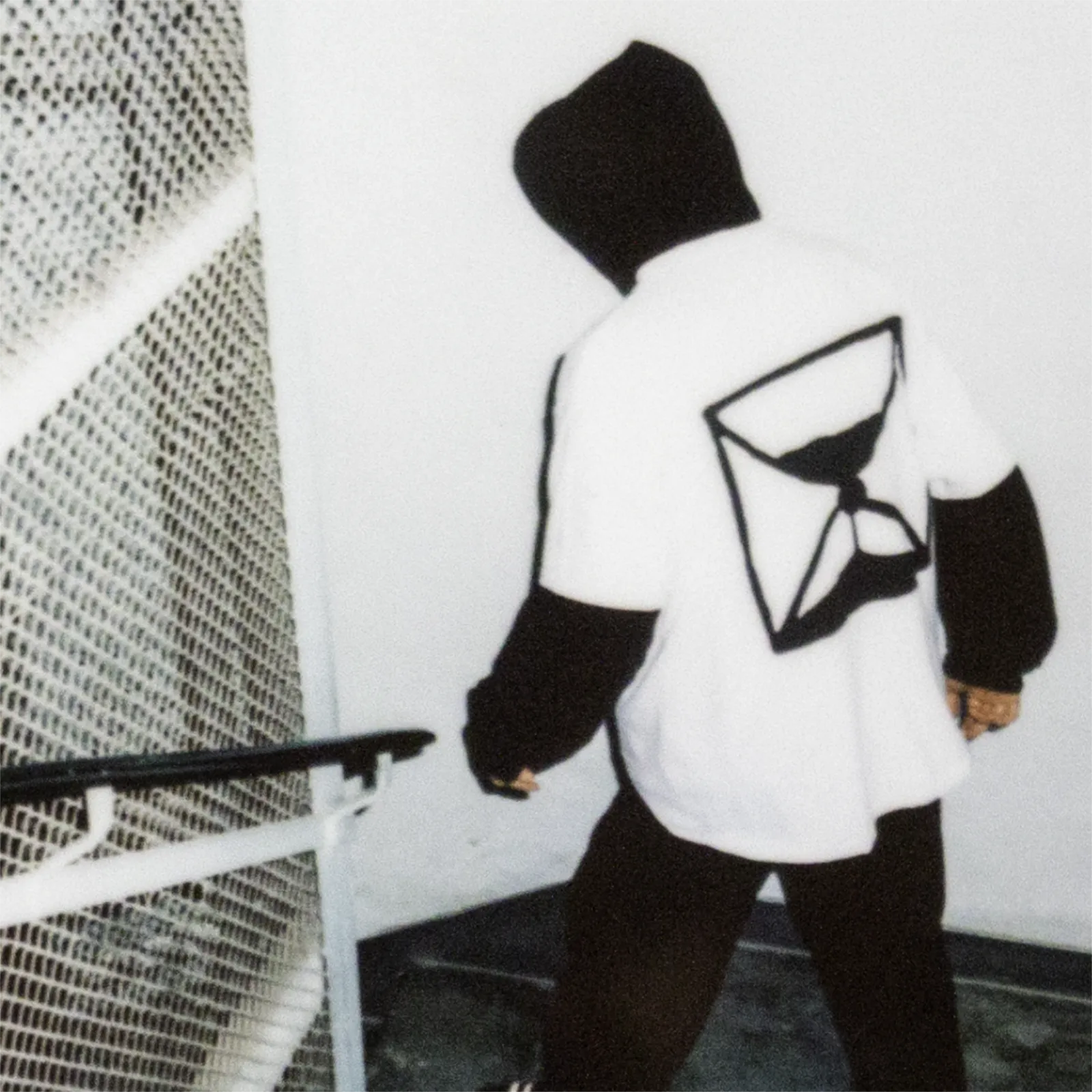 Schodzący po schodach mężczyzna ubrany w koszulkę z symbolem klepsydry