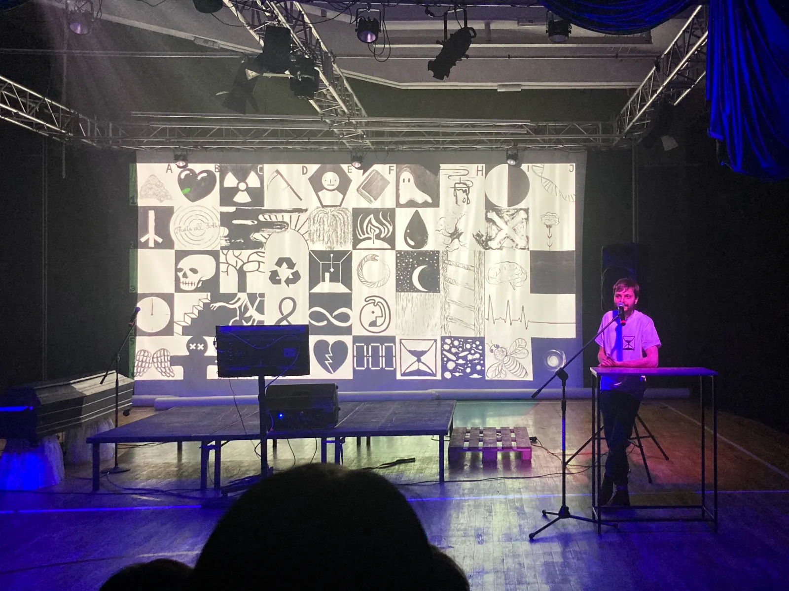 Autor na scenie i obraz wyświetlany na ścianie w tle