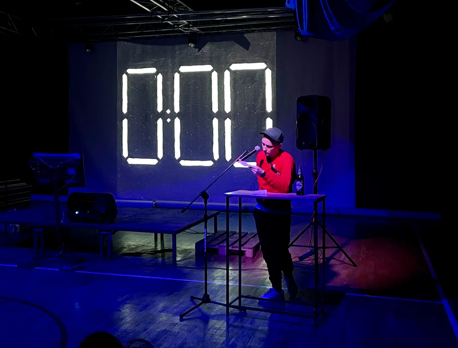 Gość występuje na scenie, w tle widoczny symbol elektronicznego zegara wskazującego 0:00